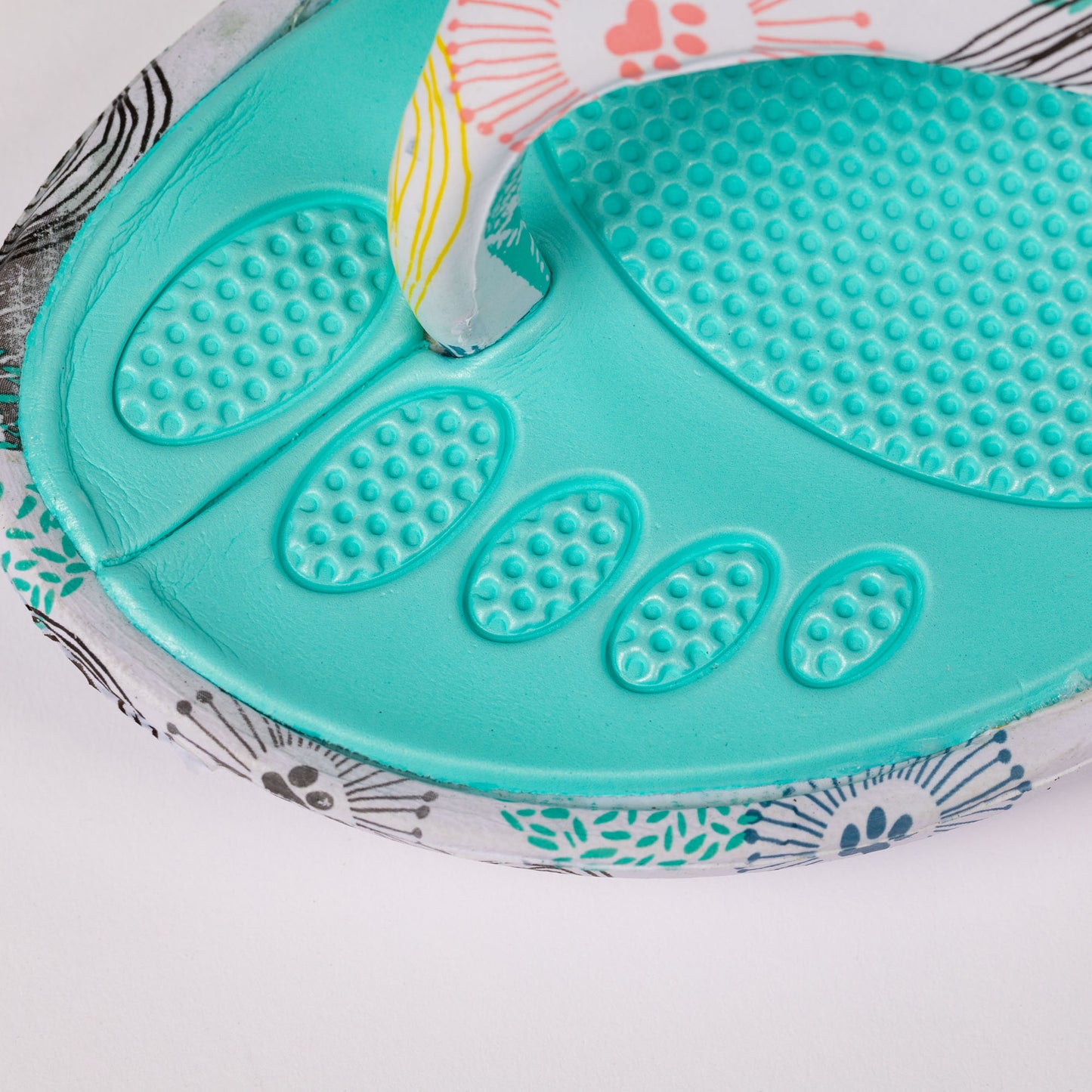 Close-up of a colorful flip-flop showcasing a textured, cushioned footbed.