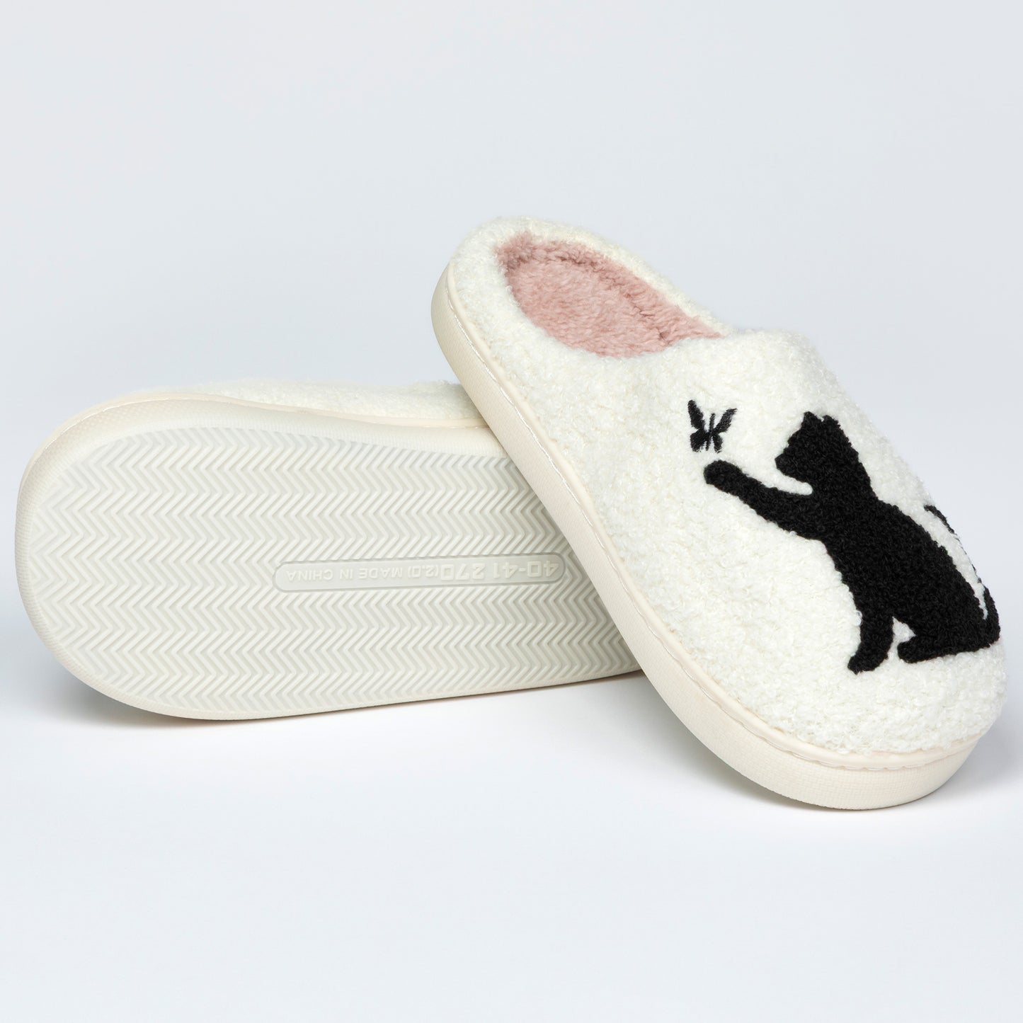 White slippers with a black cat design on a light gray background