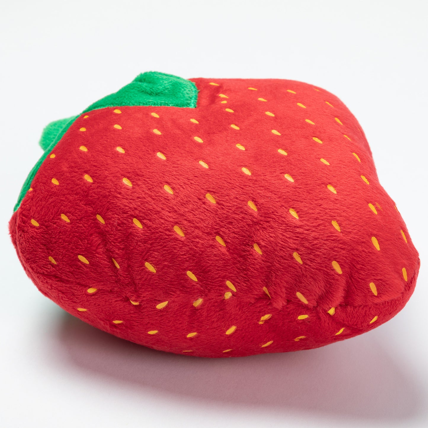 Plush strawberry dog toy on a white background