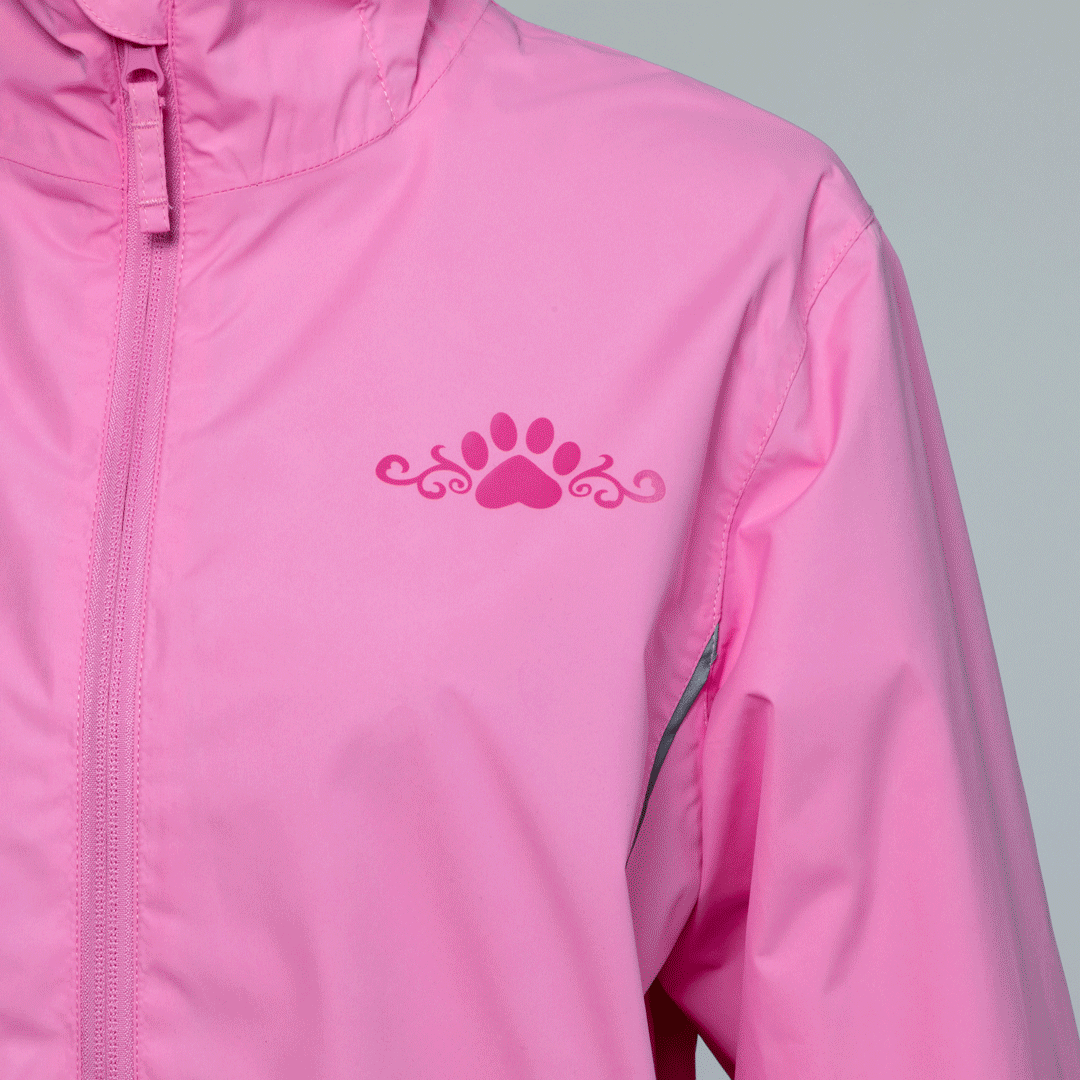 Close up of a pink rain jacket with a hidden paw pattern that activates when wet, on a white background.