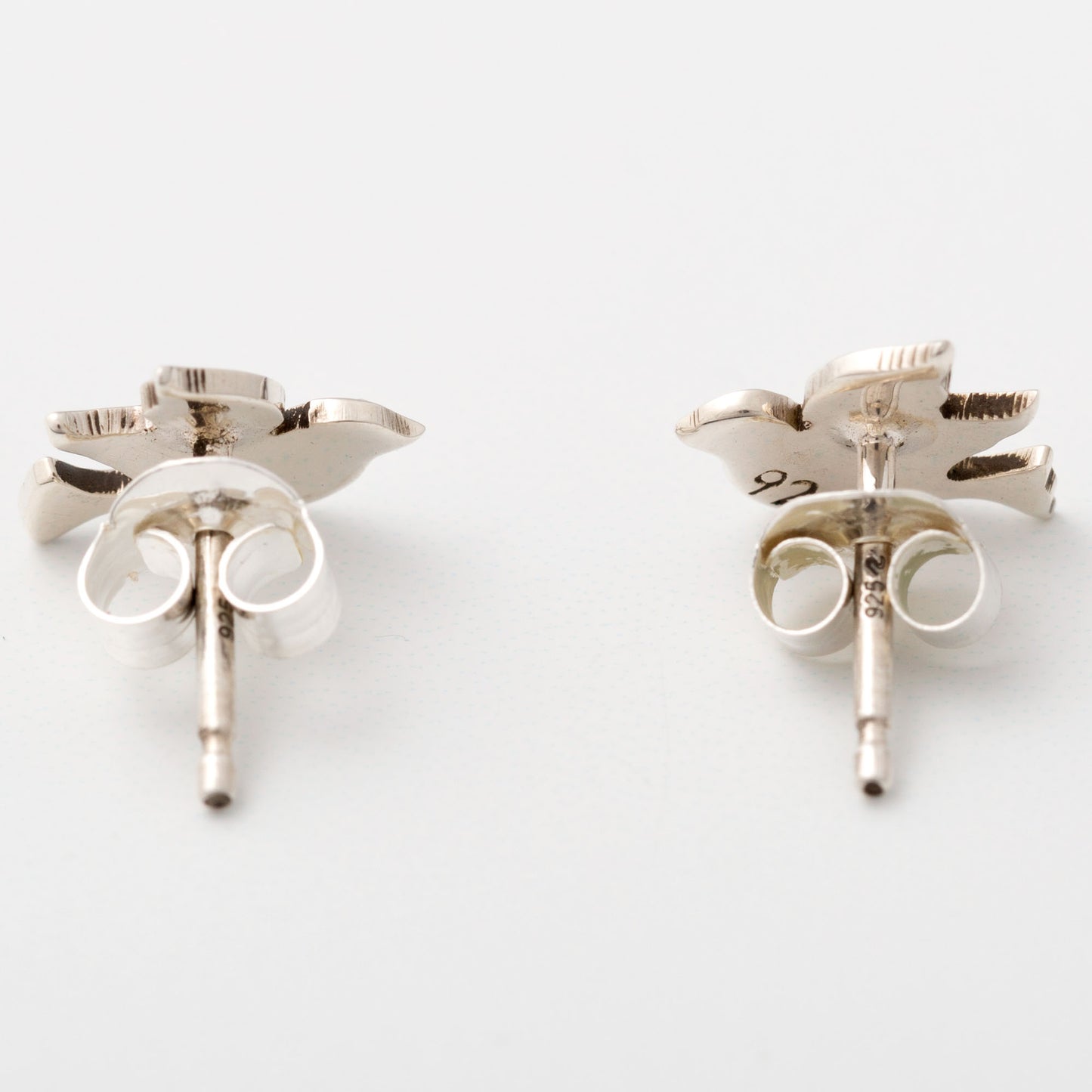 Pair of silver earrings on a white background, showing the posts and backings