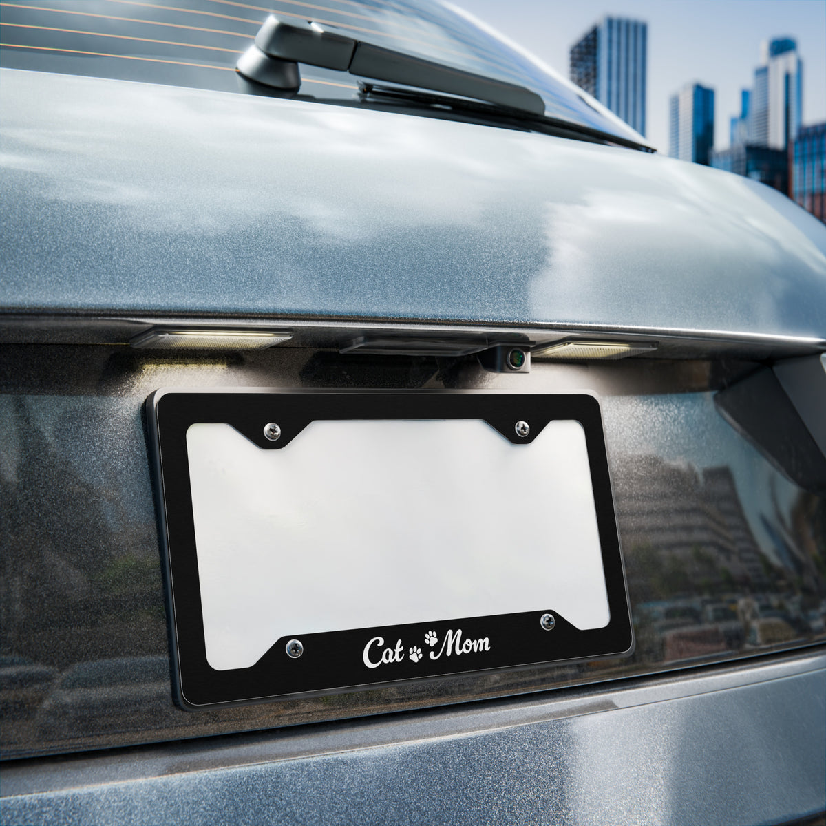 Car license plate frame with 'Cat Mom' on a vehicle in an urban setting