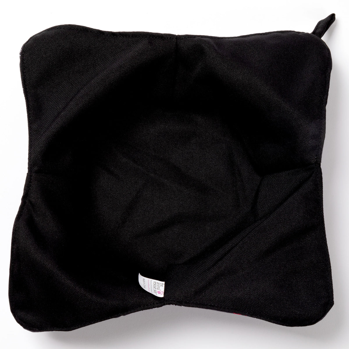 The black fabric lining of a plate cozy with a white background.