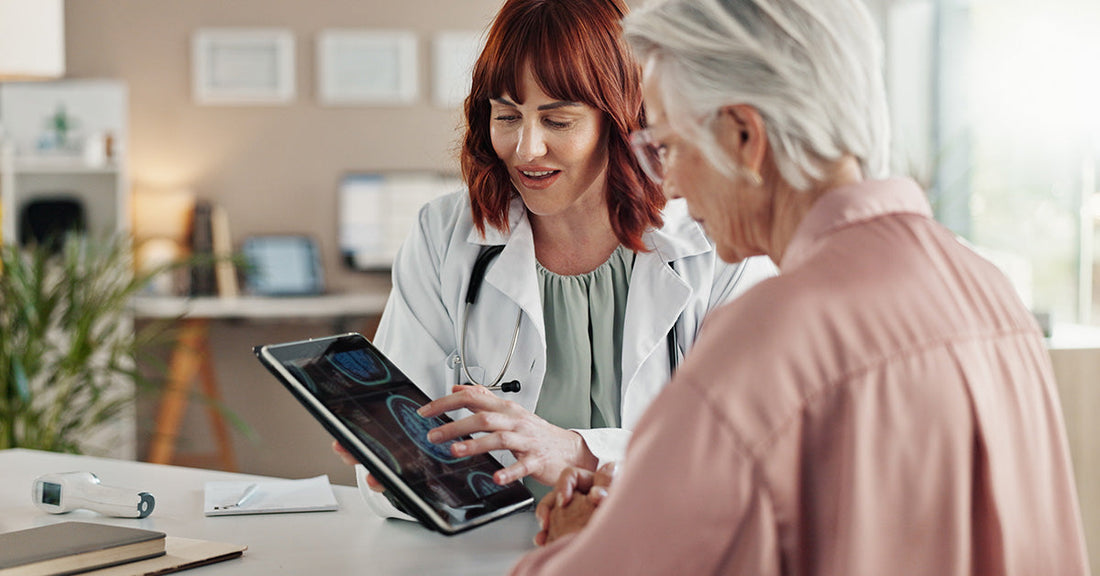 female doctor looking at brain scan with elderly patient
