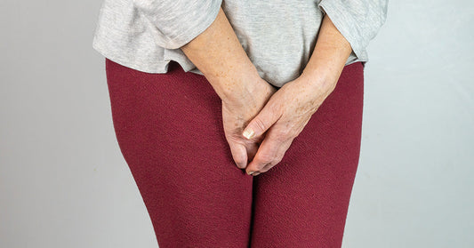 senior woman with hands between legs isolated on White background