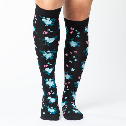 Black knee-high compression socks with paw prints and a floral pattern on a white background.