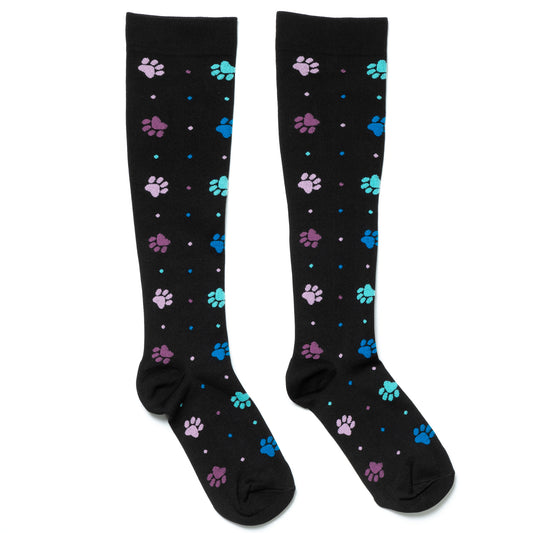 Black compression socks with polka dots and paw prints all over, on a white background.