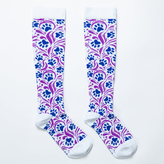 A pair of compression socks with a paw print design and swirls on a white background.