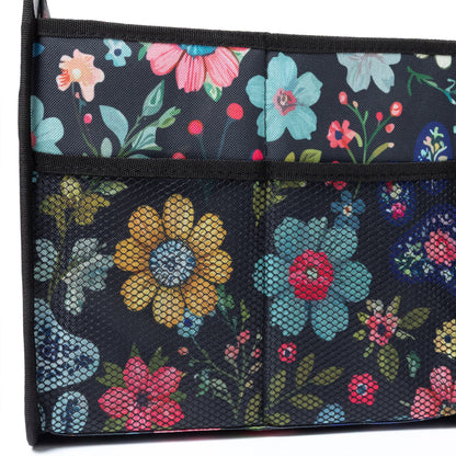 Floral-patterned trunk organizer with colorful flowers on a dark background.