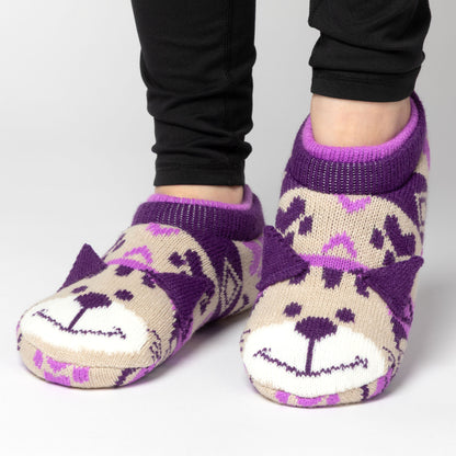 Person wearing purple and beige patterned knitted slipper socks with a smiling cat face on top, on a white background beige cat
