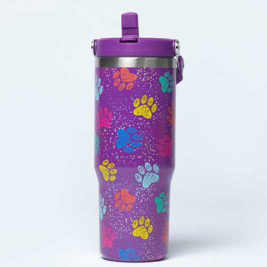 A purple insulated travel tumbler with a matching purple lid, decorated with colorful paw print patterns and white speckles, shown on a light gray background.