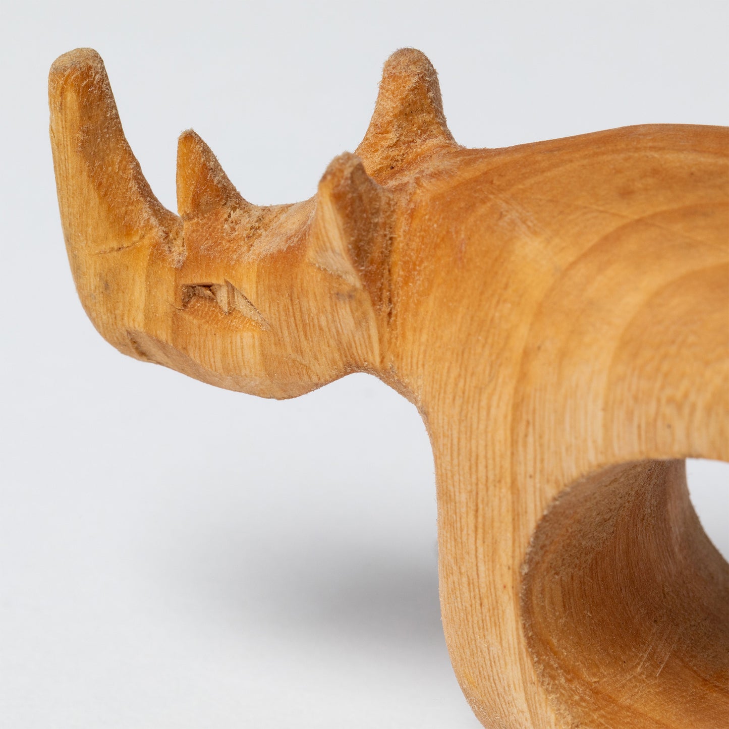 Wooden rhinoceros napkin ring on a white background.