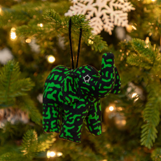 Green and black patterned elephant ornament on a Christmas tree.