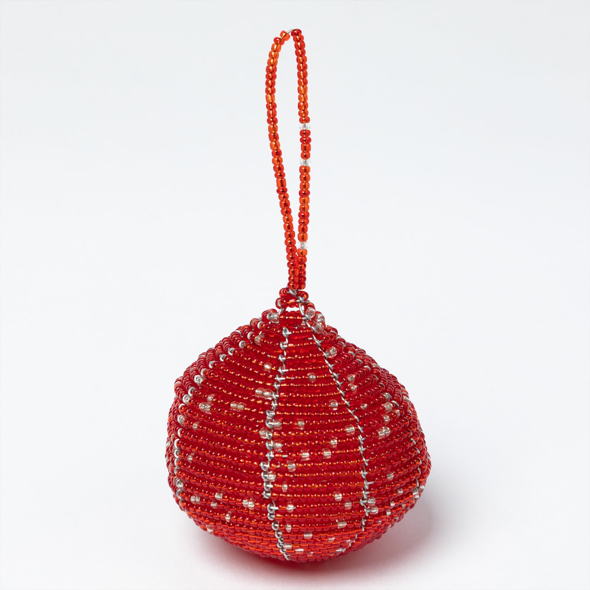 Red beaded ornament with a string on a white background