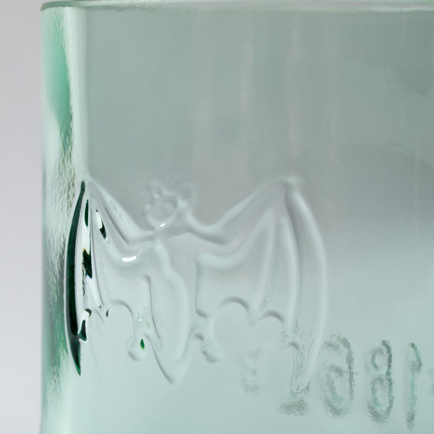 Green glass with embossed design on a white background