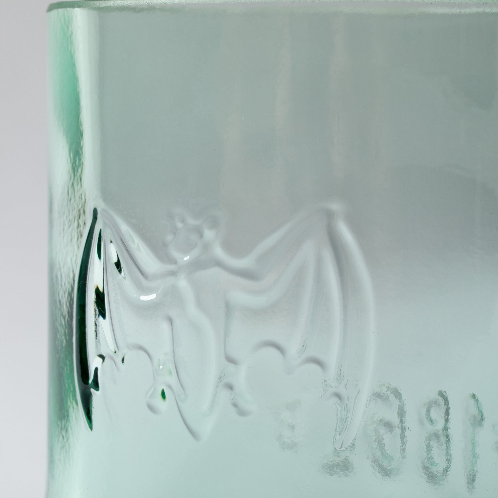 Green glass with embossed design on a white background