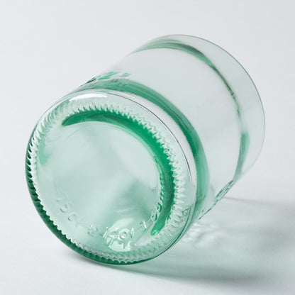Close-up of a green glass bottle on a light gray background