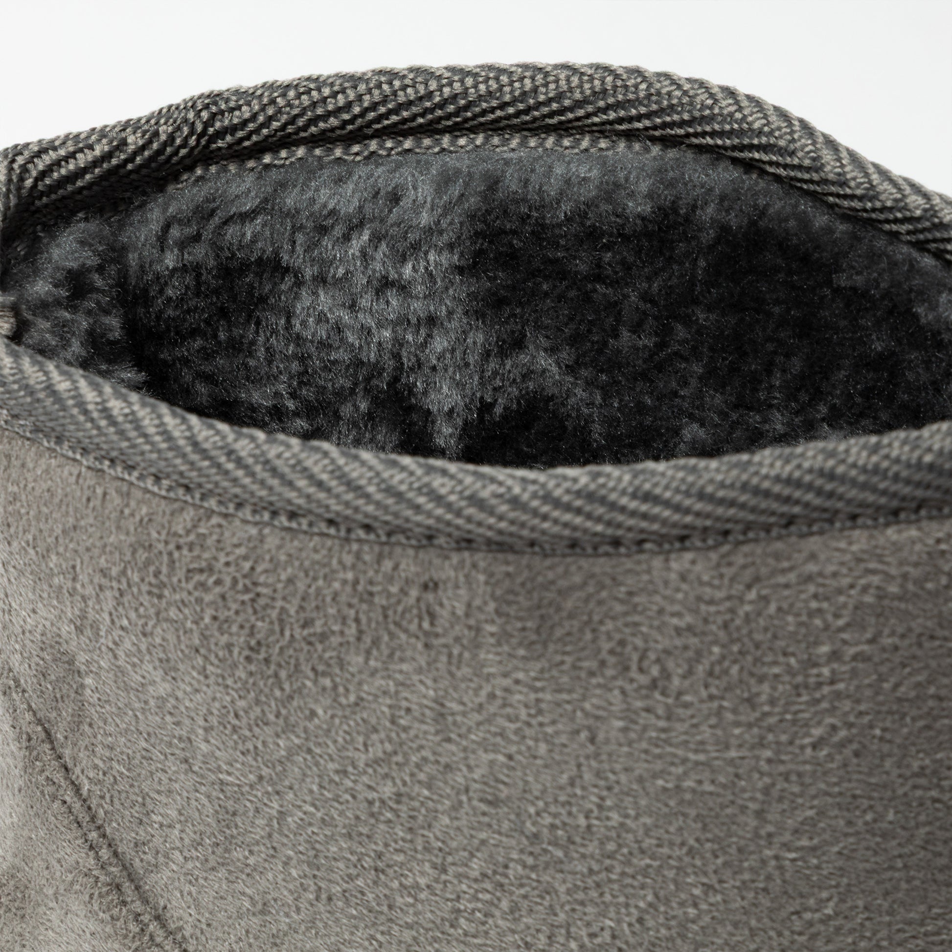 Close-up of a textured gray fabric with a soft black interior lining.