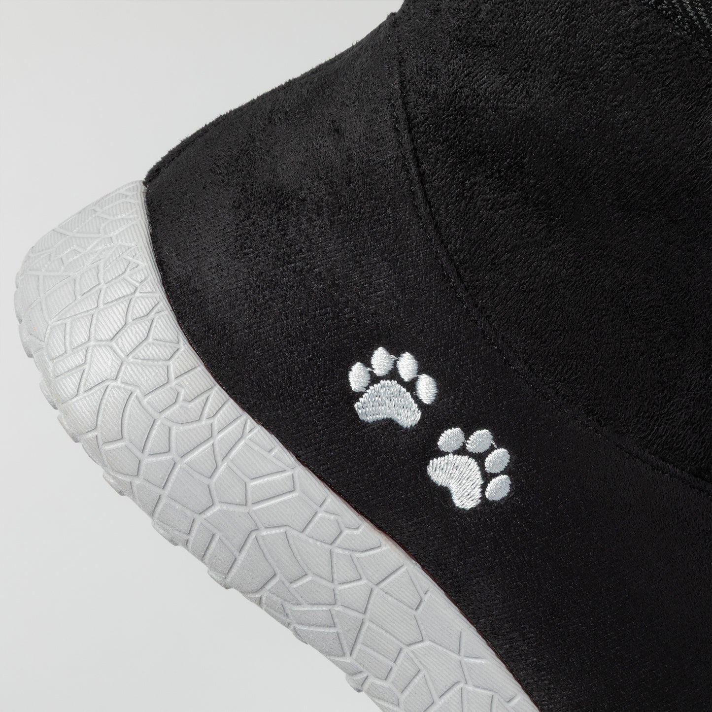 Black shoe with white paw prints on a gray background