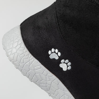 Black shoe with white paw prints on a gray background