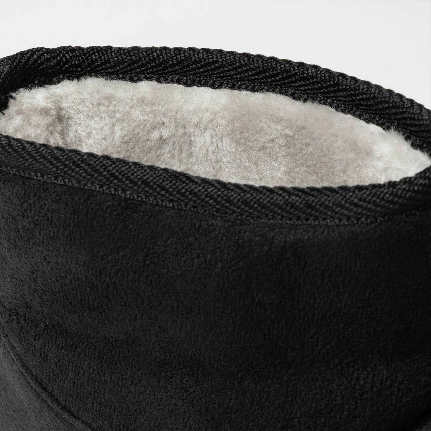 Close-up of a black shoe with white lining on a light gray background