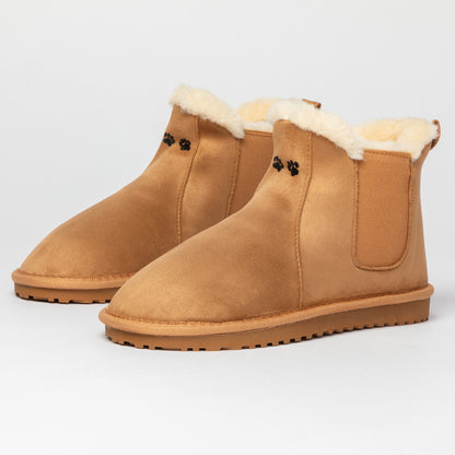 Pair of tan suede boots with fur lining on a light gray background