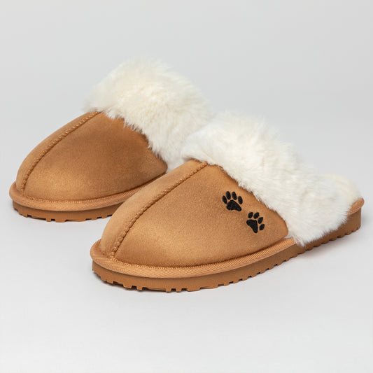 Pair of tan slippers with white fur lining and paw print design on a light gray background