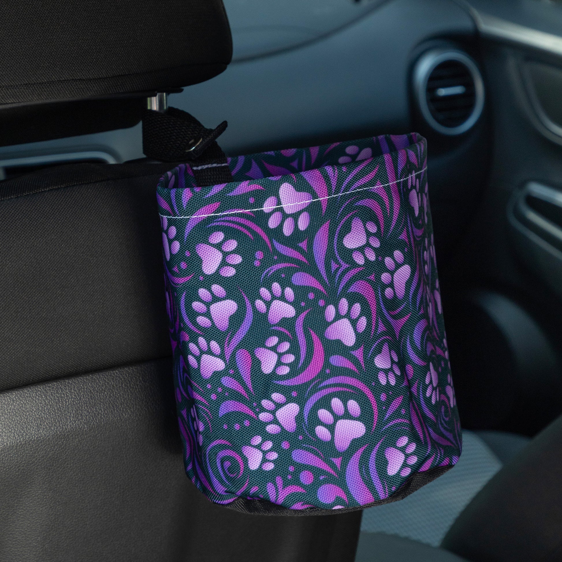 Car trash can with purple floral pattern attached to a car's interior.