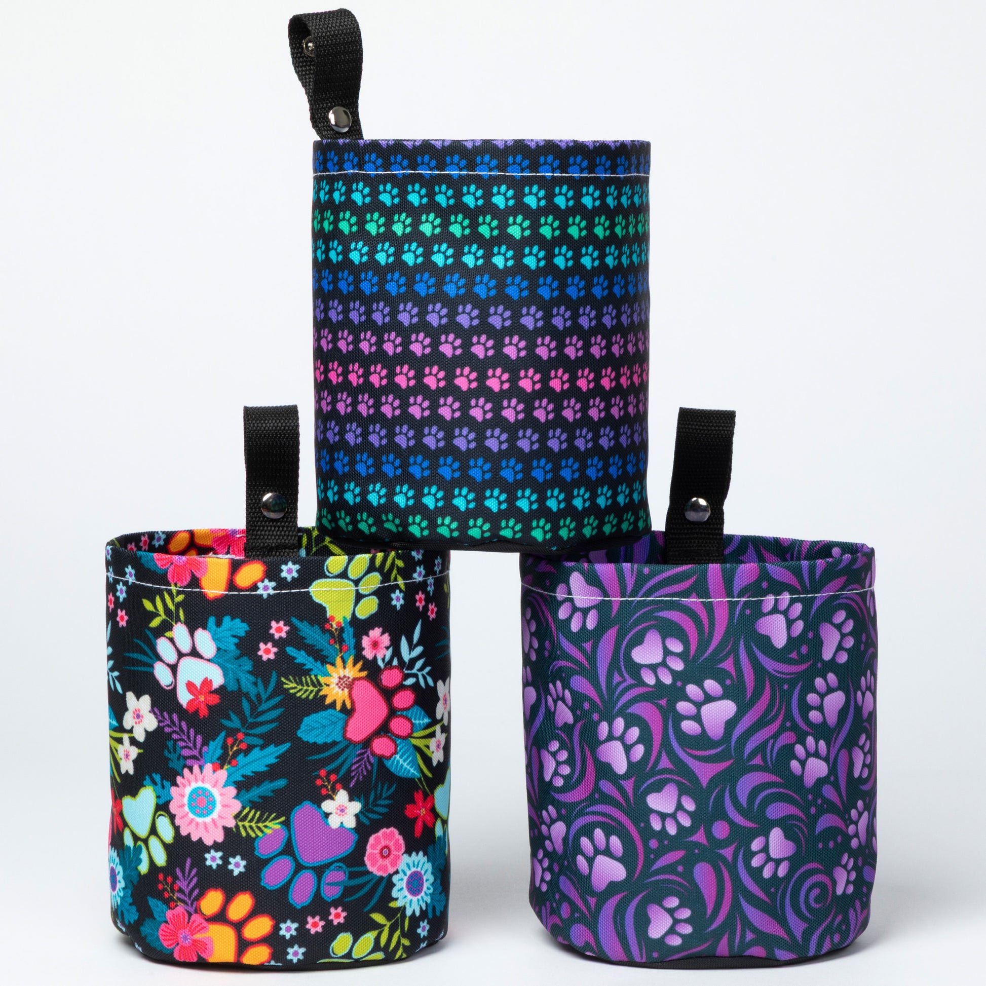 Three colorful fabric pouches with floral, paw print, and butterfly patterns on a white background.