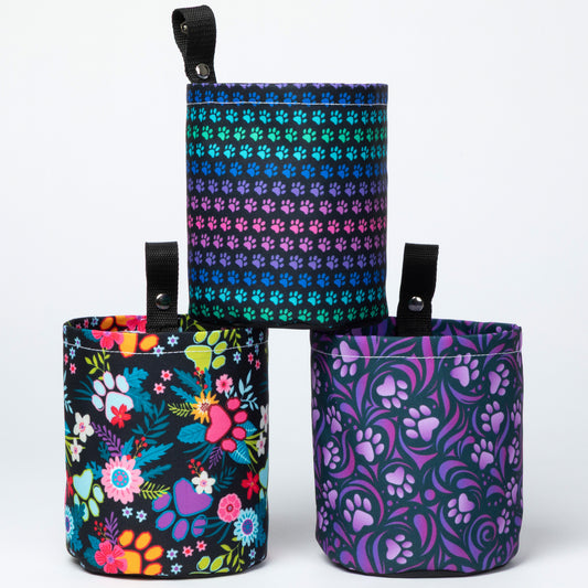 Three colorful fabric pouches with floral, paw print, and butterfly patterns on a white background.