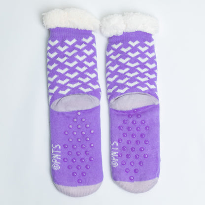 Pair of purple socks with white patterns and textured sole on a light gray background
