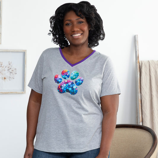 Woman wearing a gray t-shirt with a colorful paw print design, in a casual living room.