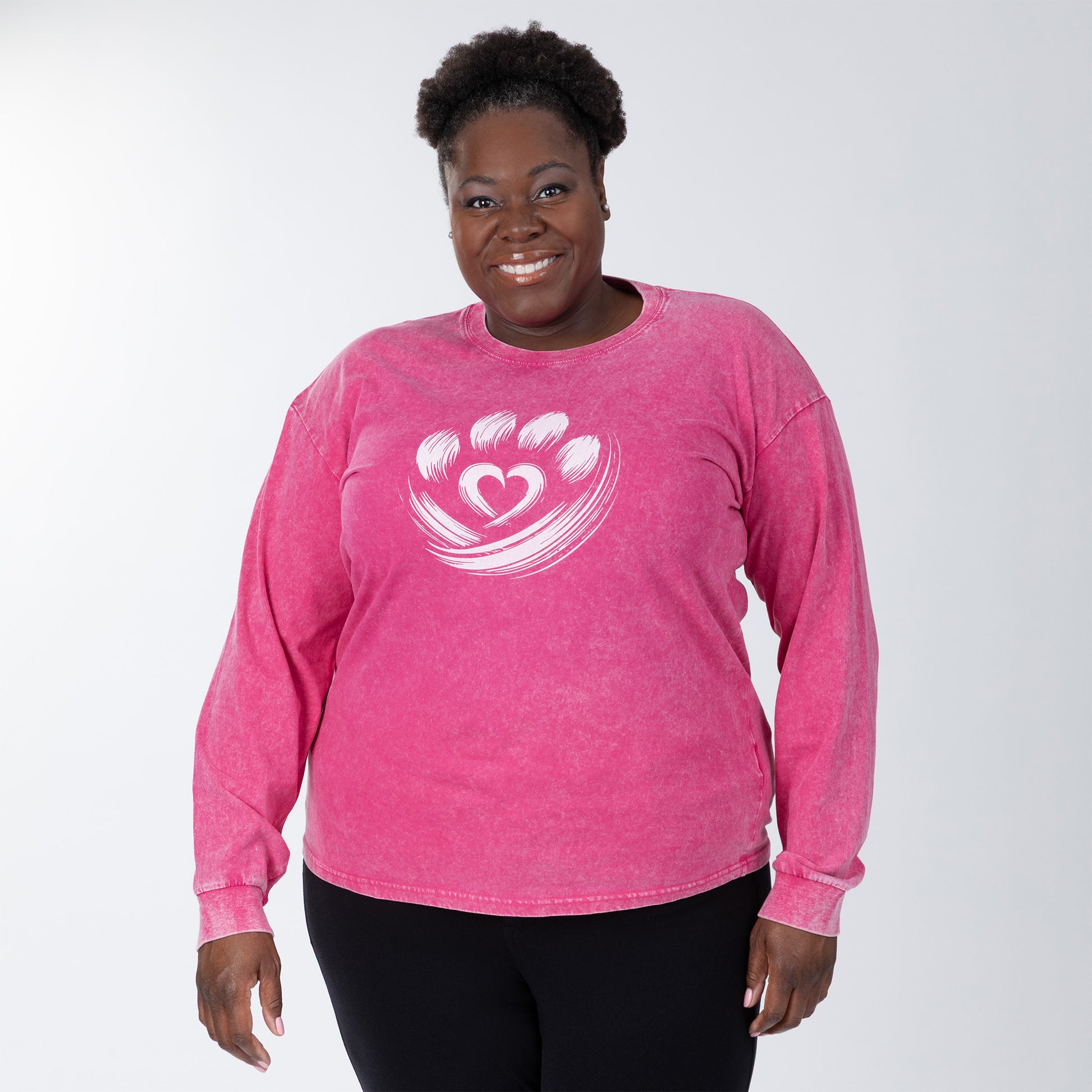 Person wearing a pink long-sleeve shirt with a heart design on a white background