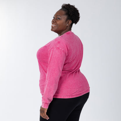 Person wearing a pink long-sleeve shirt on a white background
