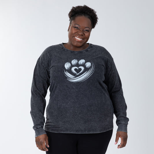 Woman wearing a dark gray long-sleeve shirt with a heart design on a white background