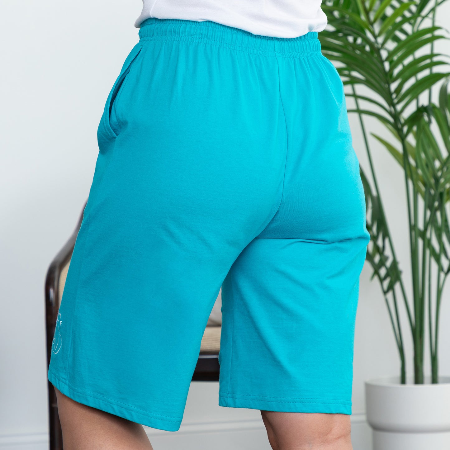 Teal shorts worn by a person in a living room setting