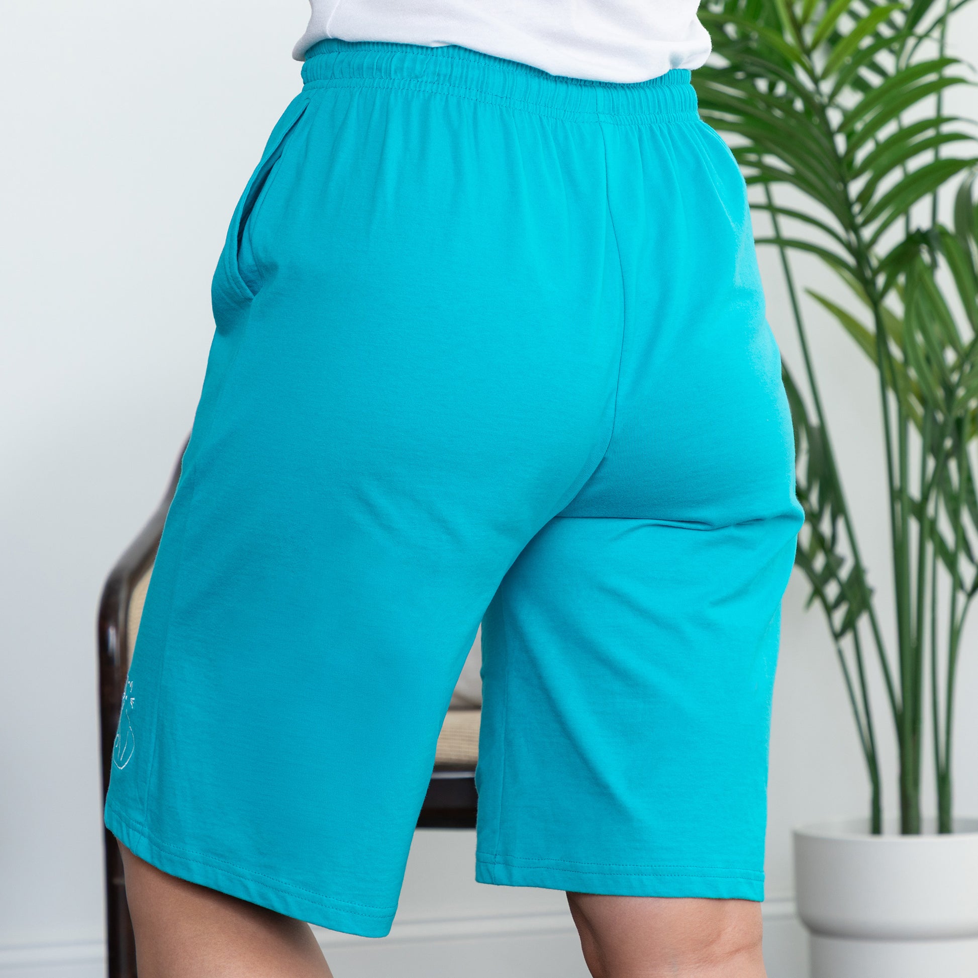 Teal shorts worn by a person in a living room setting