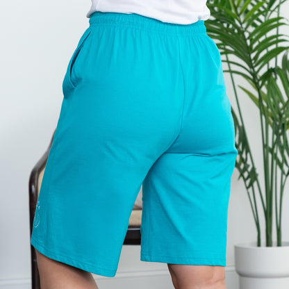Teal shorts worn by a person in a living room setting