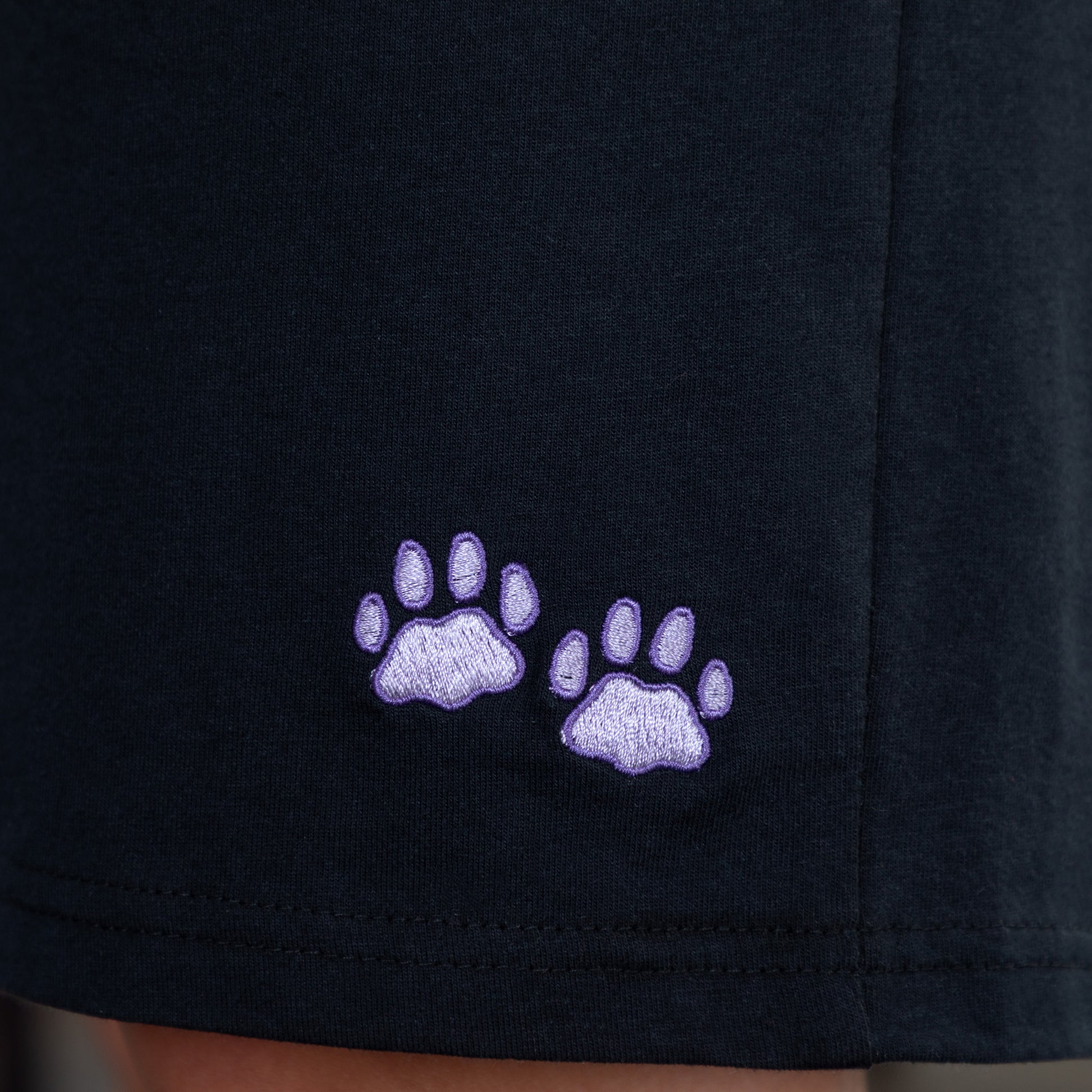 Black shorts with purple paw prints embroidered on the left leg.