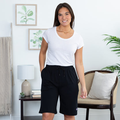 Woman wearing a white t-shirt and black shorts in a home setting