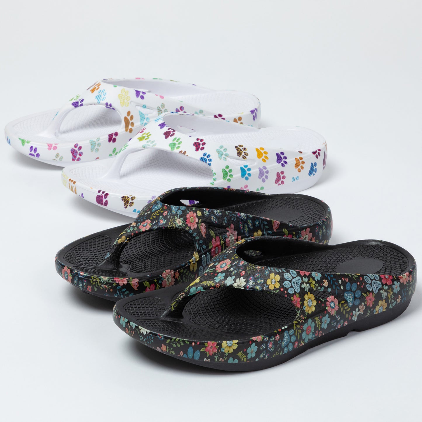 Pair of paw print and floral-patterned sandals on a white background