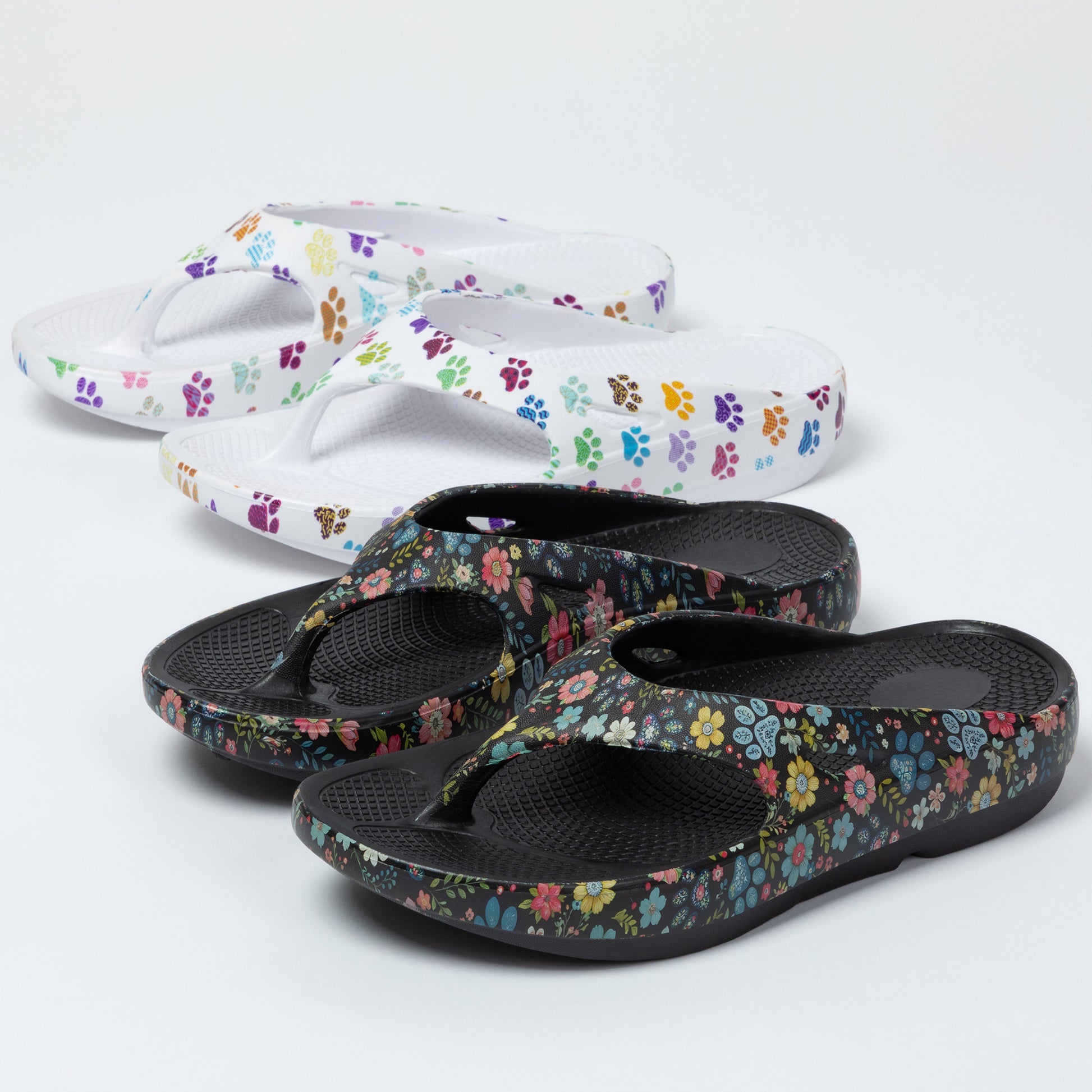 Pair of paw print and floral-patterned sandals on a white background