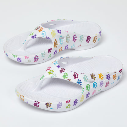Pair of white sandals with colorful paw print pattern on a white background