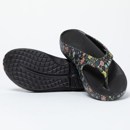 Pair of floral-patterned sandals with black soles on a white background