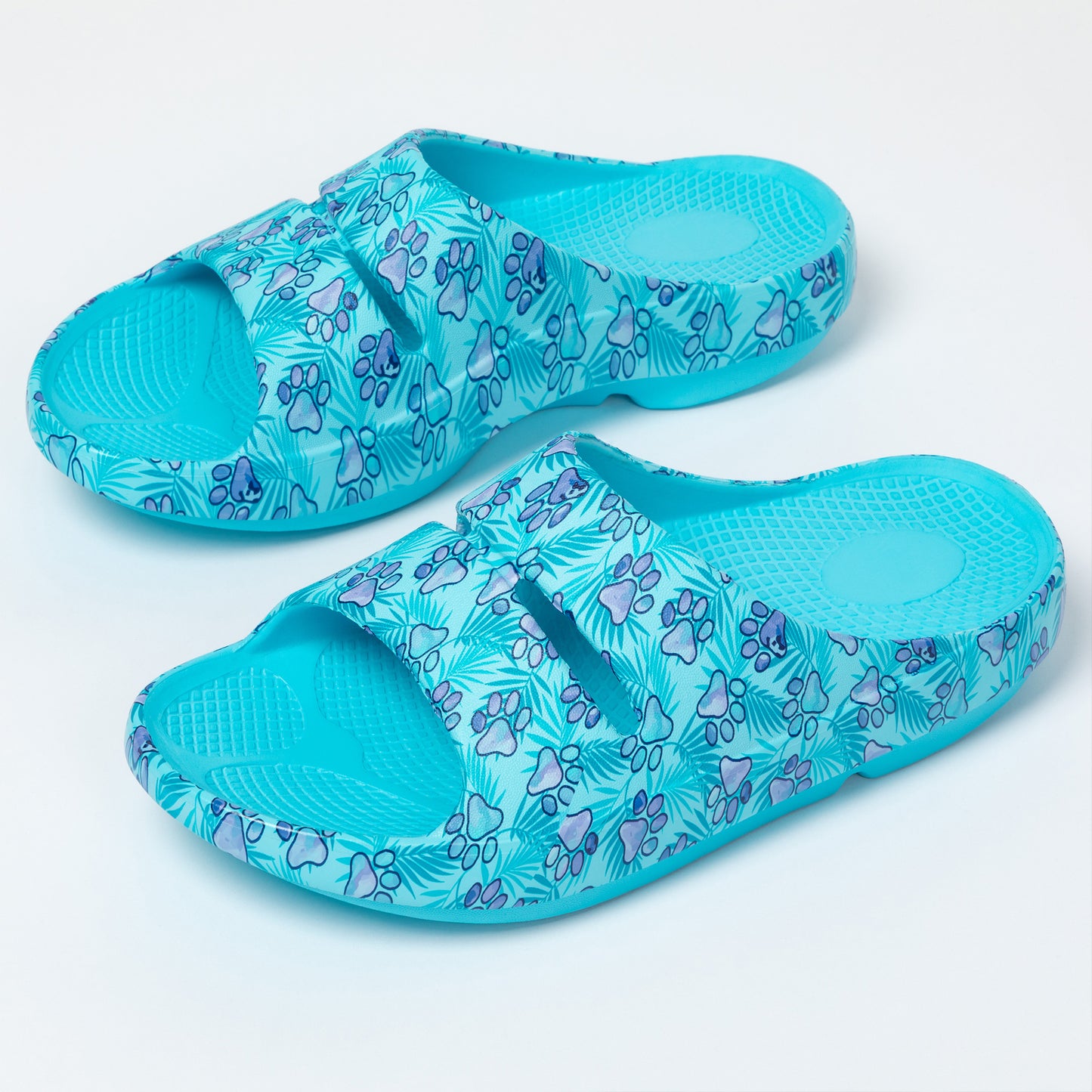 Pair of blue sandals with paw print pattern on a light gray background