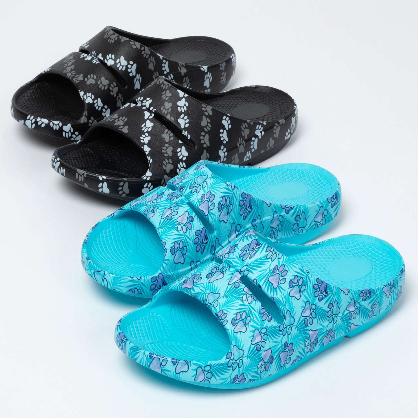 Pair of blue sandals and a pair of black sandals with paw print pattern on a white background