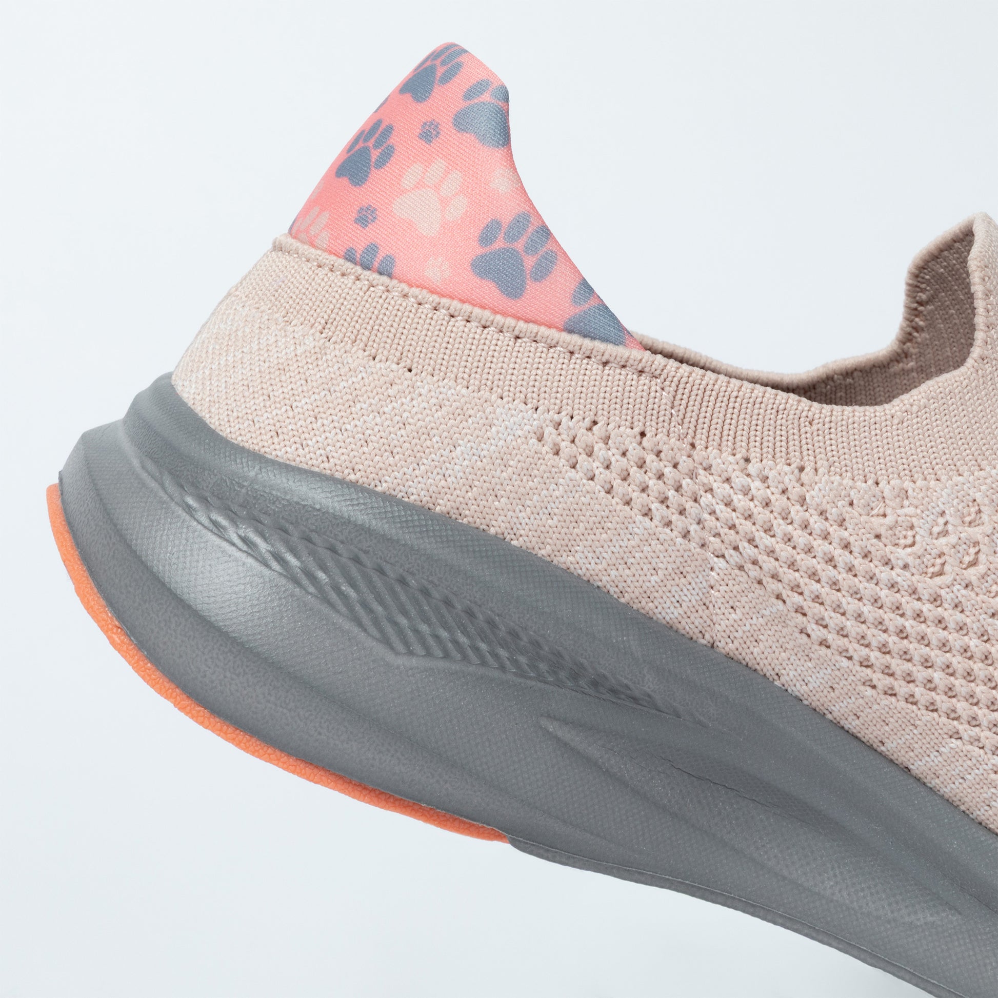 Beige sneaker with paw print accents on a light gray background