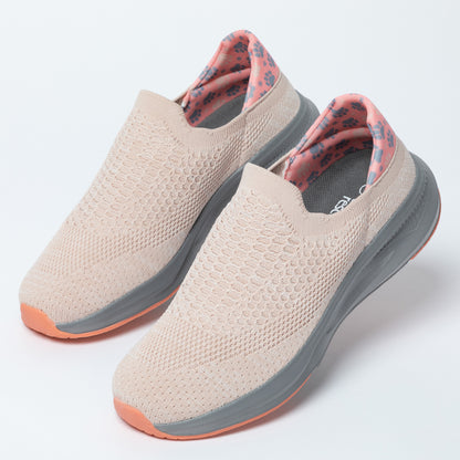 Pair of beige slip-on shoes with gray soles on a white background