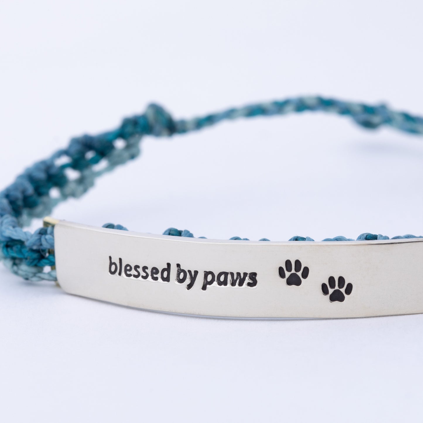Bracelet with 'blessed by paws' text and paw prints on a white background