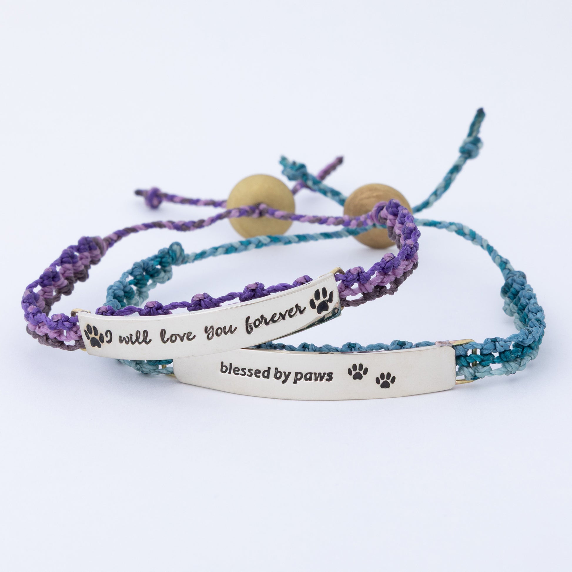 Two hand braided bracelets with engraved messages on a white background